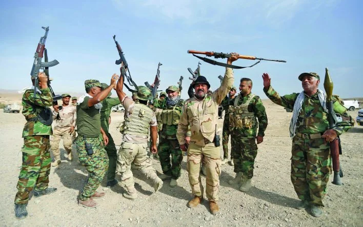 Shi'ite fighters chant slogans in al-Fatha, northeast of Baiji